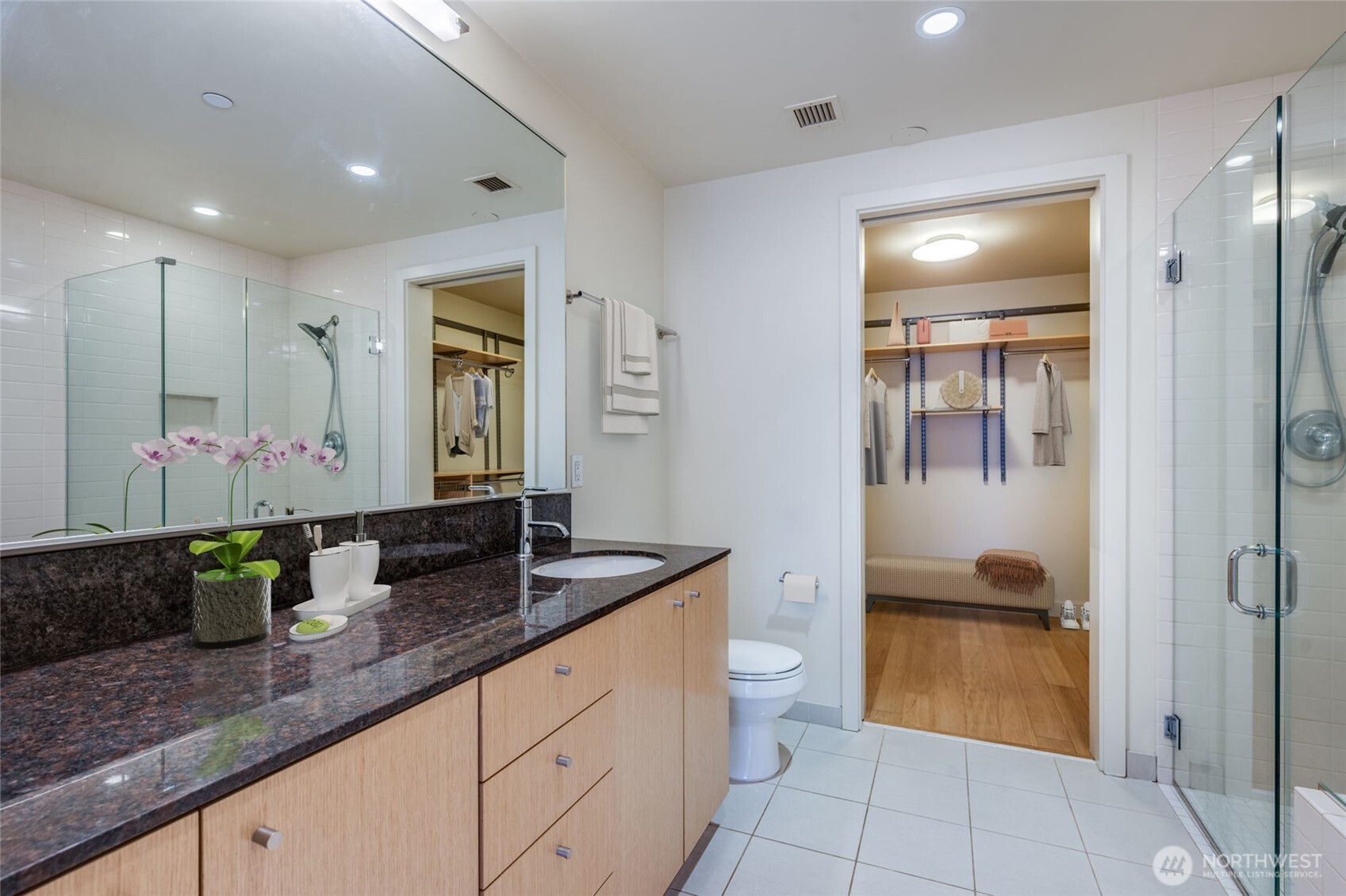 909 5th Avenue, Unit 1203 Seattle, WA 98164 - Photo 22 of 32 a bathroom with a granite countertop sink a toilet and a mirror