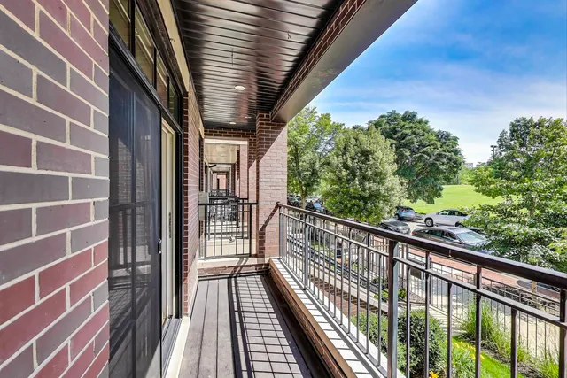 a view of balcony with wooden floor and fence and floor to ceiling window