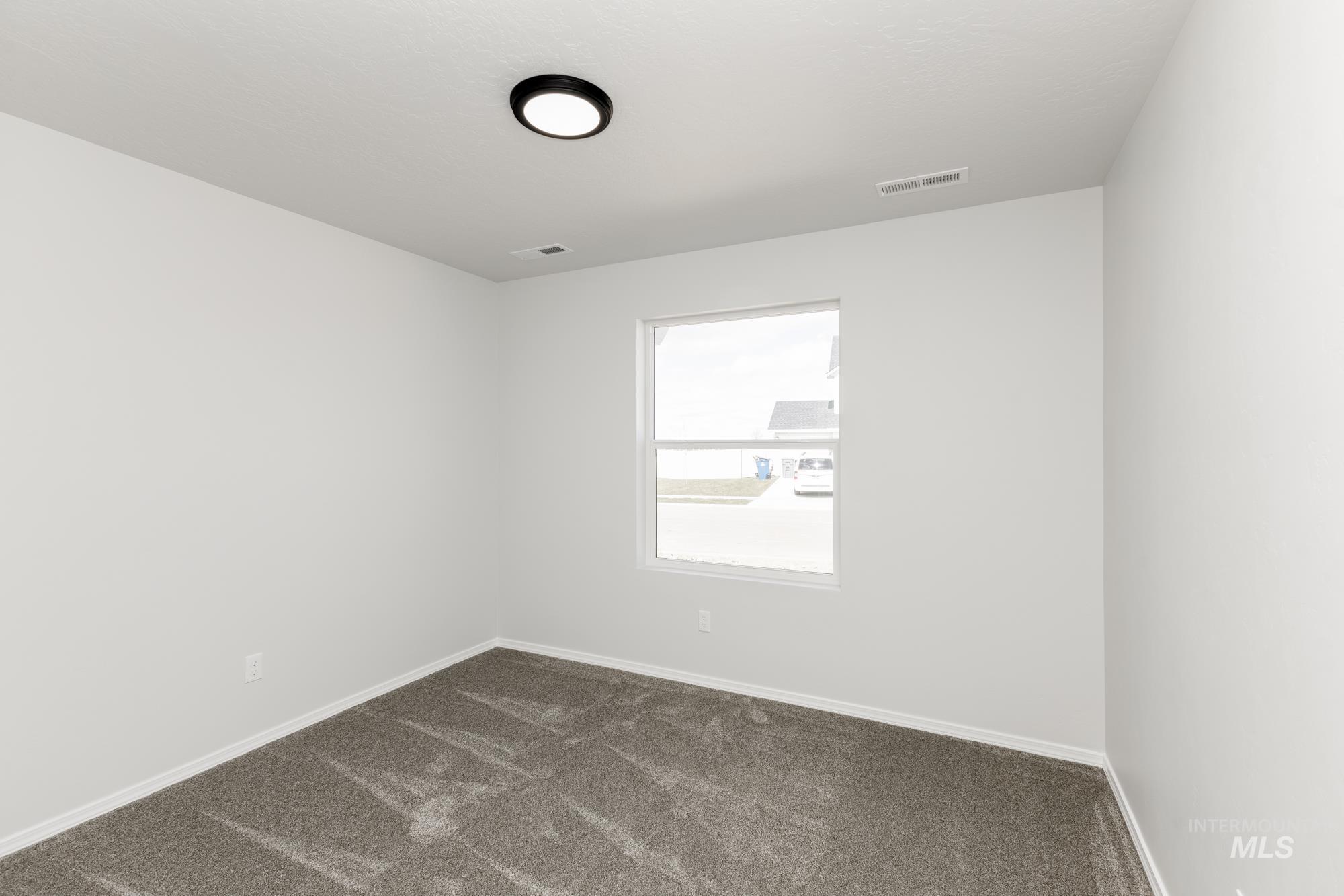 13668 Judson Street Caldwell, ID 83607 - Photo 9 of 17 Empty room featuring dark colored carpet and baseboards