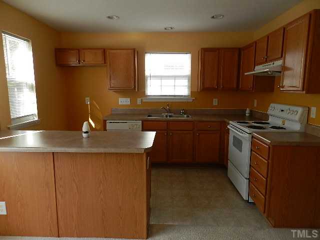 8020 River Watch Lane Raleigh, NC 27616 - Photo 5 of 10 a kitchen with kitchen island granite countertop a sink a counter top space appliances and cabinets