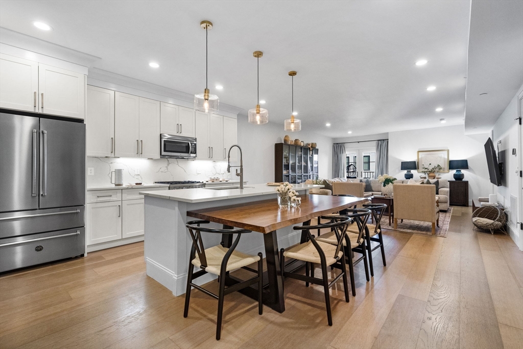 258-260 West 3rd Street, Unit 1 Boston, MA 02127 - Photo 1 of 37 a kitchen with stainless steel appliances kitchen island granite countertop a table chairs and a refrigerator