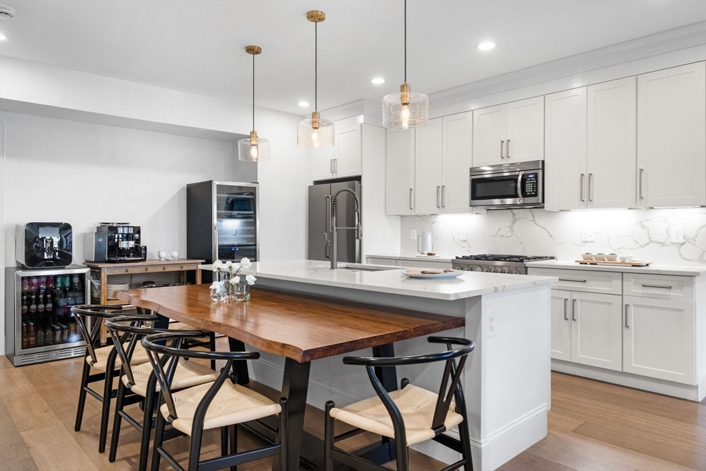 258-260 West 3rd Street, Unit 1 Boston, MA 02127 - Photo 12 of 37 a kitchen with kitchen island granite countertop a sink and a refrigerator
