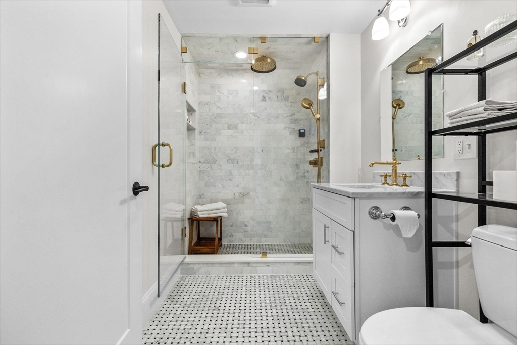 258-260 West 3rd Street, Unit 1 Boston, MA 02127 - Photo 20 of 37 a bathroom with a granite countertop shower a toilet and a sink