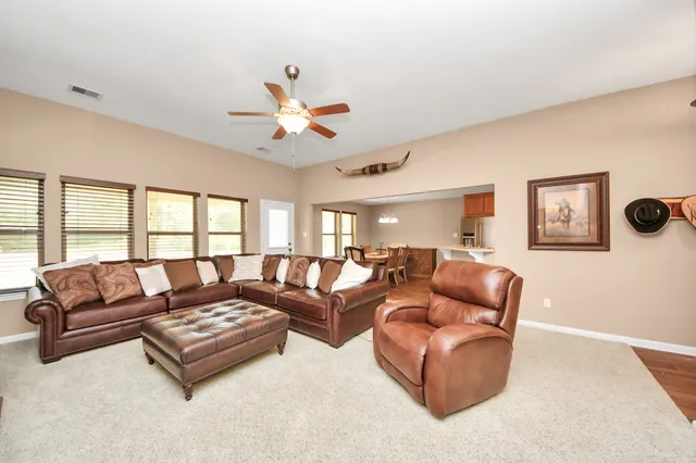 a view of an empty room with window and a ceiling fan