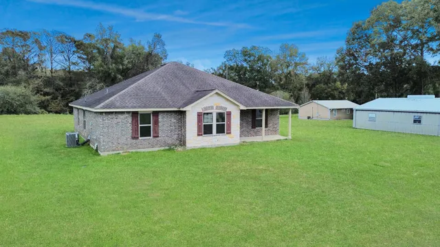 a aerial view of a house next to a yard with large tree