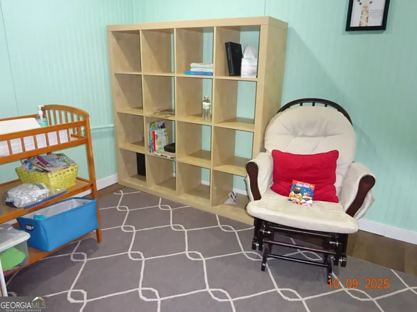 a living room with furniture a rug and a wall painting