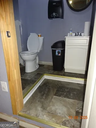 a bathroom with a toilet and a mirror