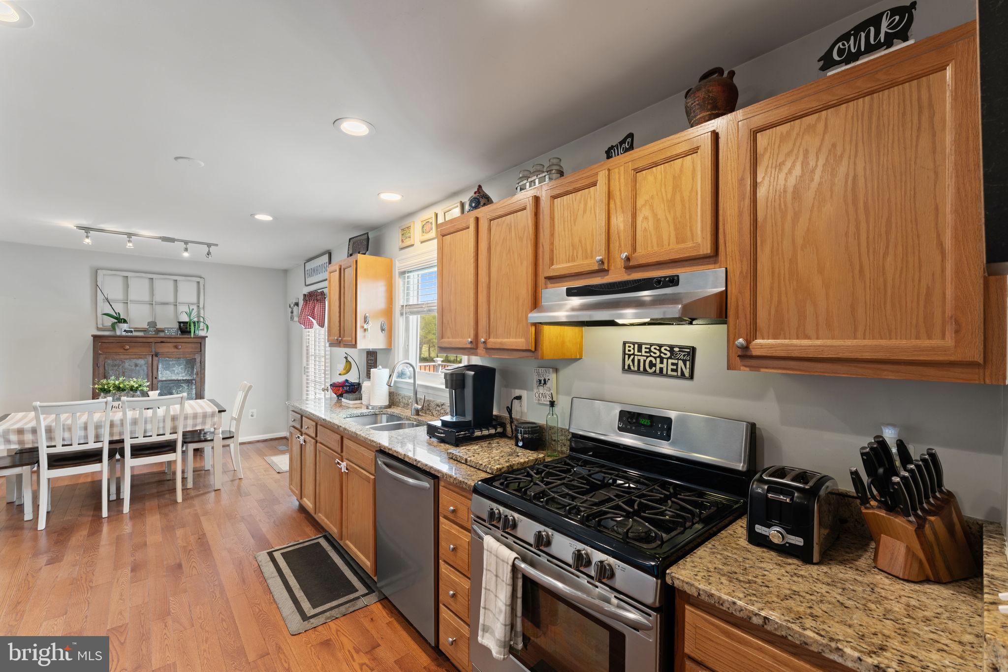 1388 Novum Church Road Reva, VA 22735 - Photo 23 of 65 a kitchen with stainless steel appliances granite countertop a stove top oven a sink dishwasher and cabinets with wooden floor