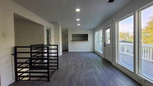 a view of hallway with wooden floor and windows
