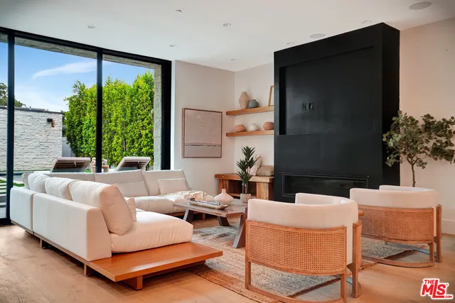 a kitchen with stainless steel appliances kitchen island granite countertop a stove a sink a dining table and chairs with wooden floor