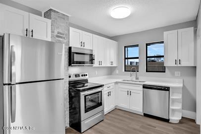 2125 Gilmore Street Jacksonville, FL 32204 - Photo 9 of 18 a kitchen with white cabinets and stainless steel appliances