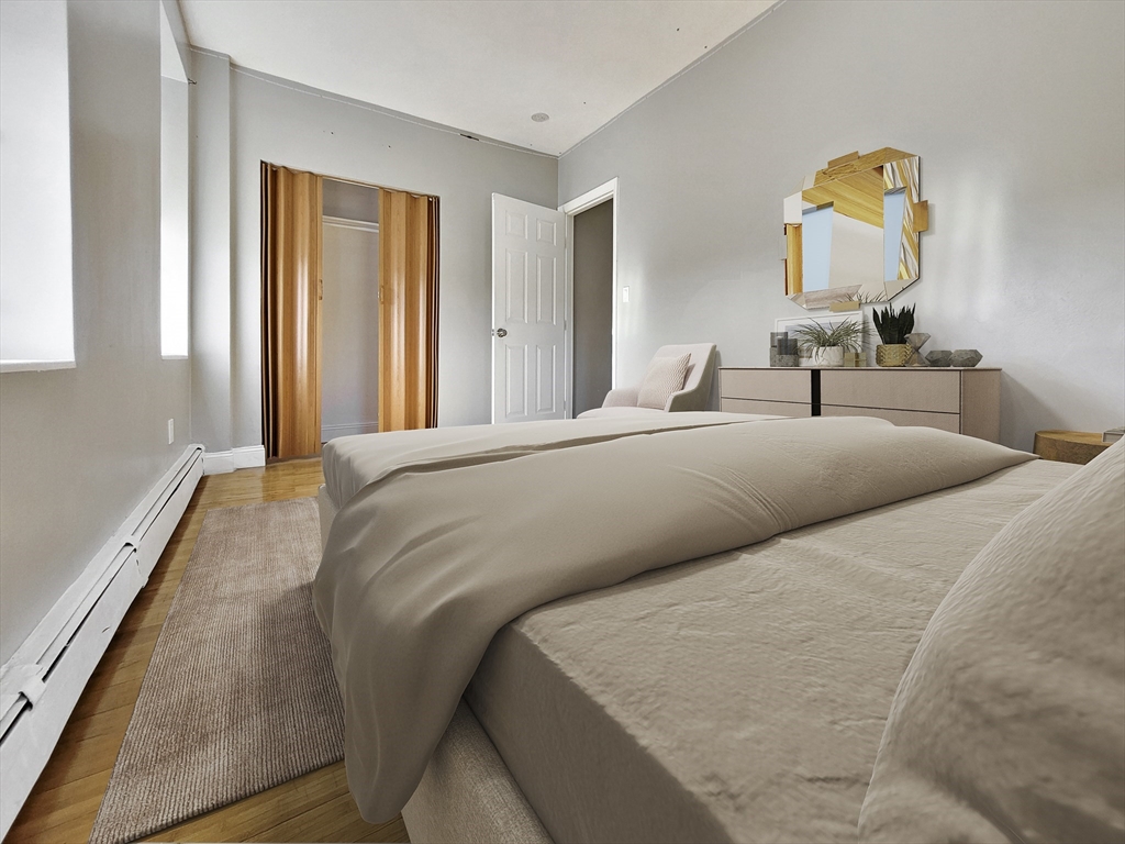 338-342 Warren Street, Unit 6 Boston, MA 02119 - Photo 6 of 7 a bedroom with a bed and a painting on the wall