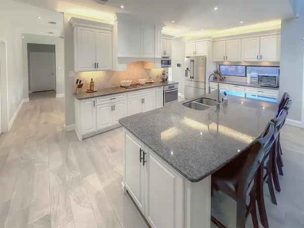 a large kitchen with stainless steel appliances kitchen island granite countertop a large counter top and sink