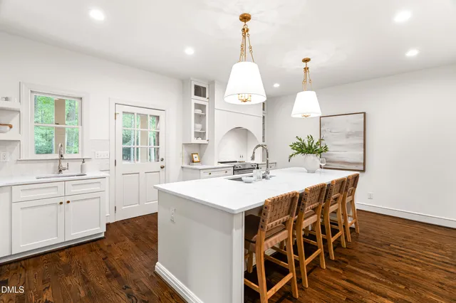 a kitchen with granite countertop white cabinets and white appliances