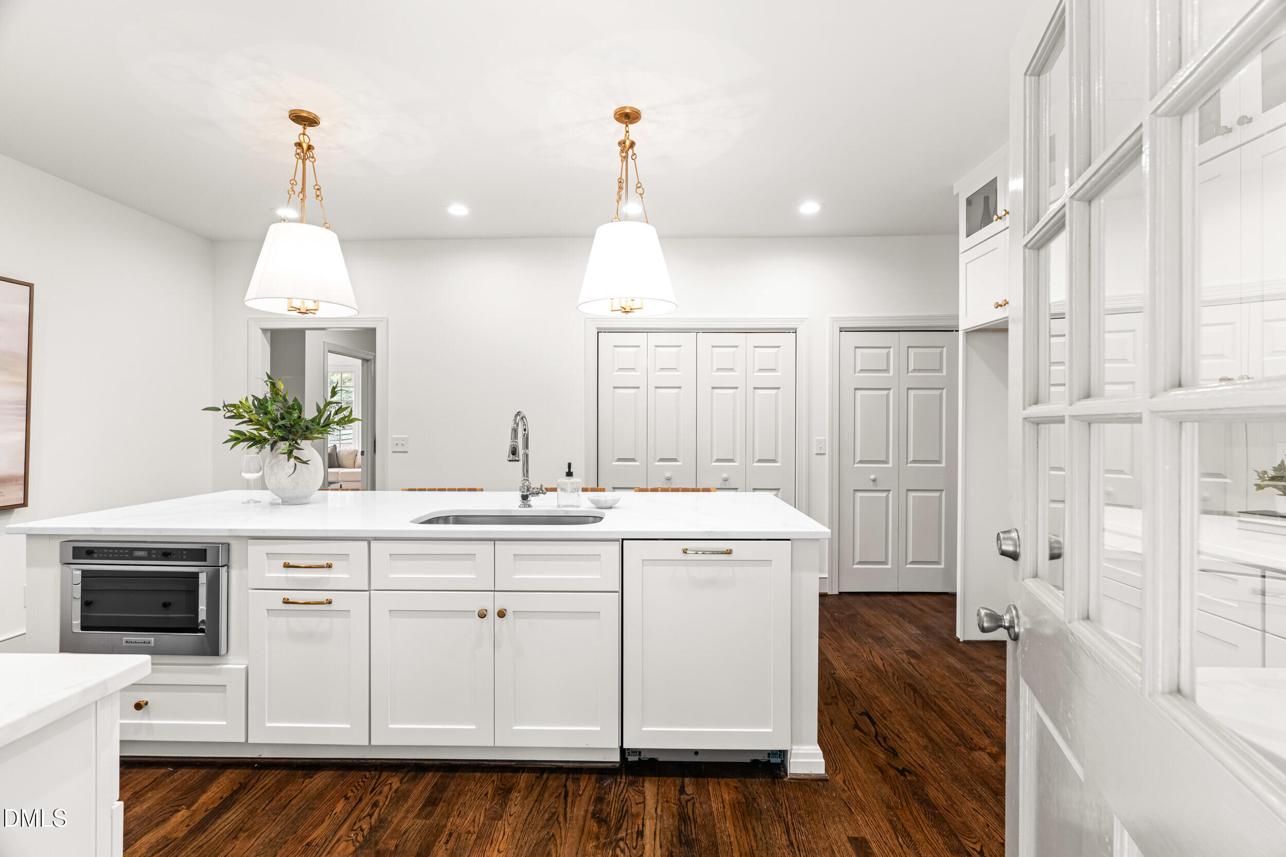 1015 Mulberry Road Clayton, NC 27520 - Photo 19 of 46 a kitchen with a sink dishwasher a stove and a dining table with wooden floor