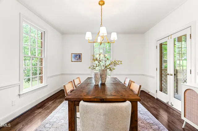 a kitchen with a sink dishwasher a stove and a dining table with wooden floor