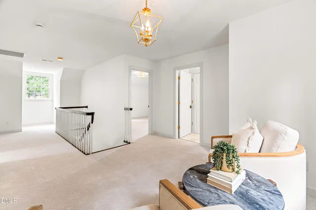 a living room with furniture a chandelier and a window