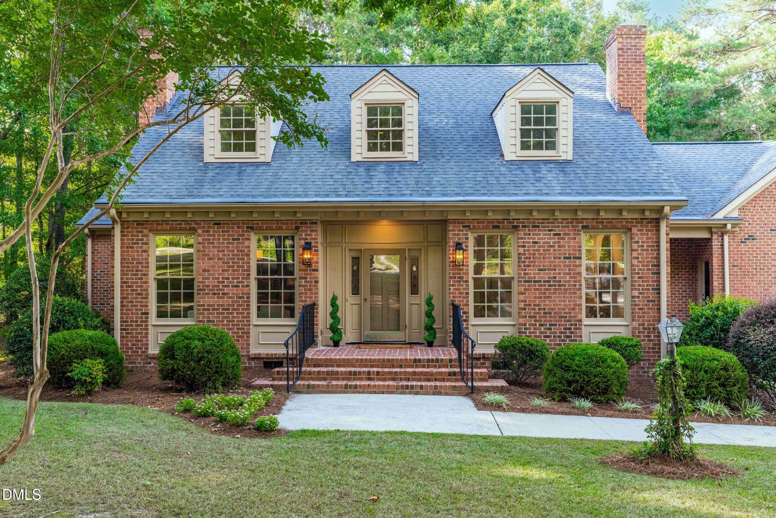 1015 Mulberry Road Clayton, NC 27520 - Photo 5 of 46 a view of a house with brick walls and a yard with plants