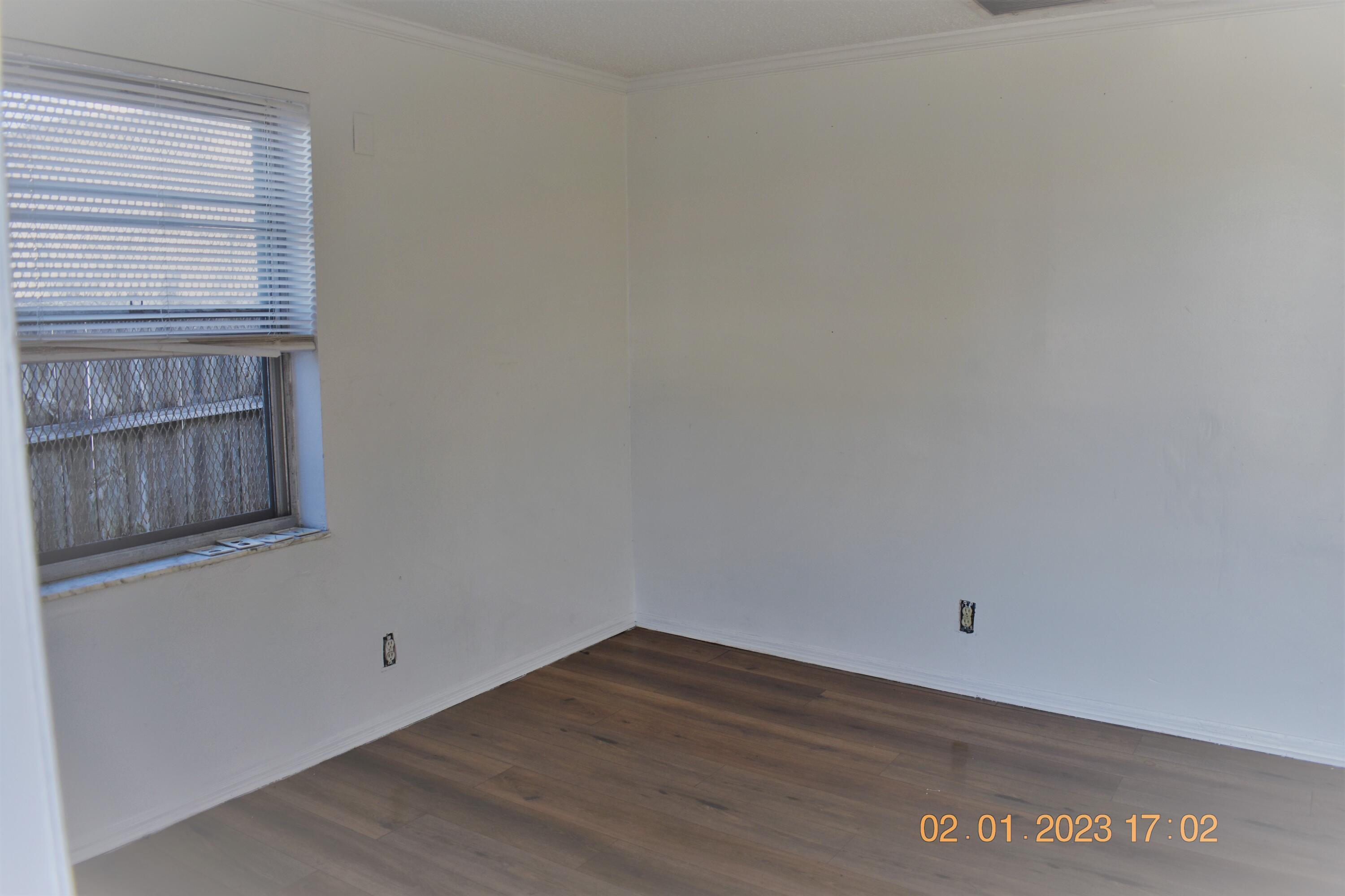 1305 West 25th Street Riviera Beach, FL 33404 - Photo 6 of 10 a view of an empty room with wooden floor and cabinet