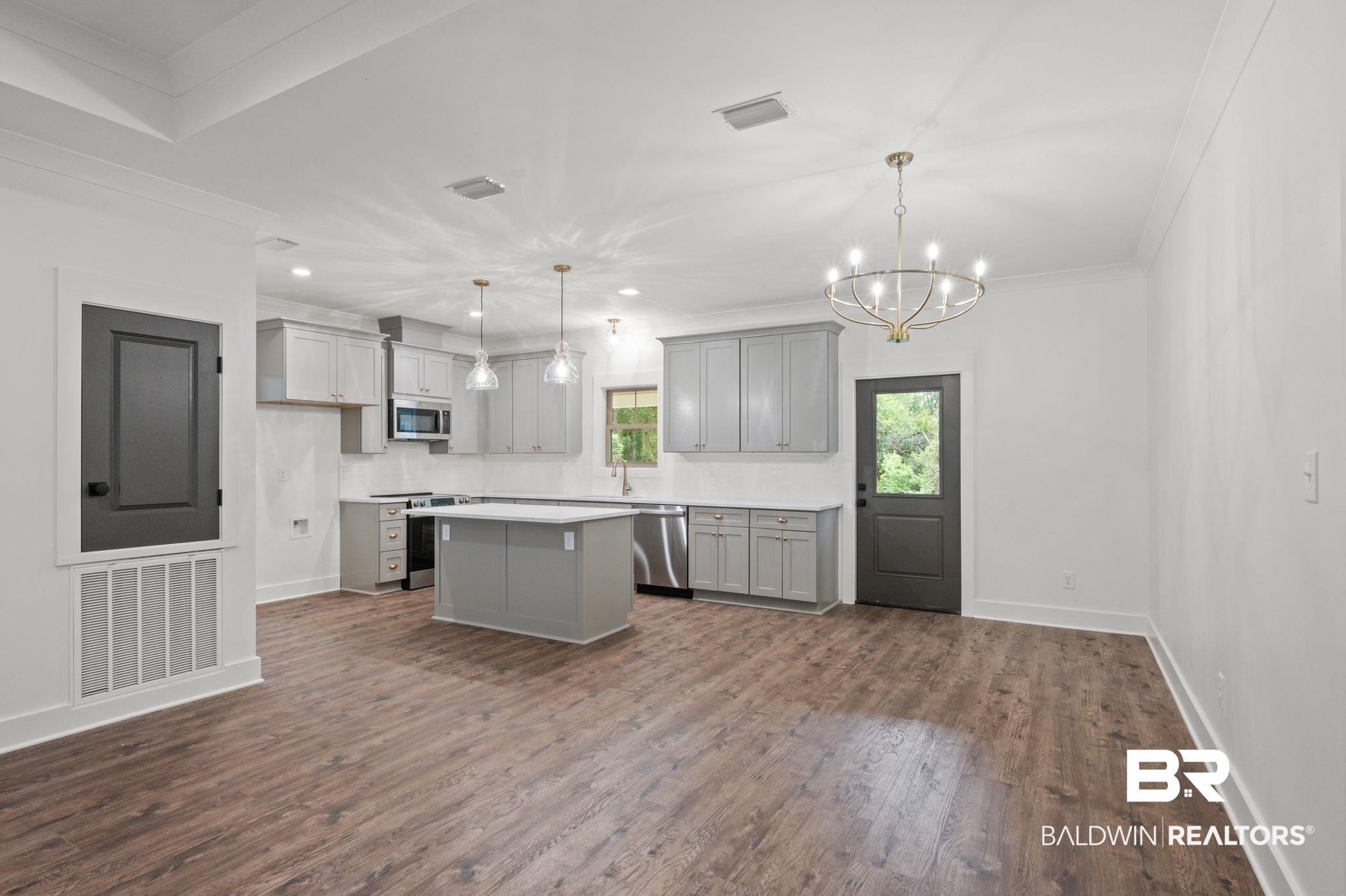12412 Mannich Lane Foley, AL 36535 - Photo 6 of 23 Kitchen featuring a kitchen island, stainless steel appliances, hardwood / wood-style floors, and gray cabinets