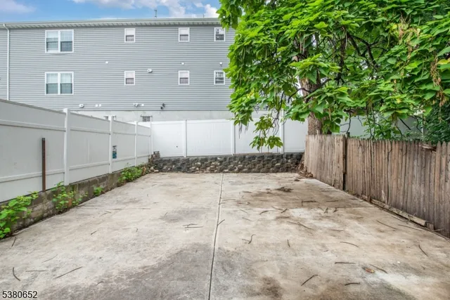 a view of backyard with table and chairs and wooden fence