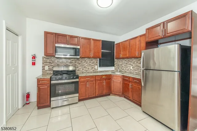 a kitchen with stainless steel appliances granite countertop a refrigerator sink and stove