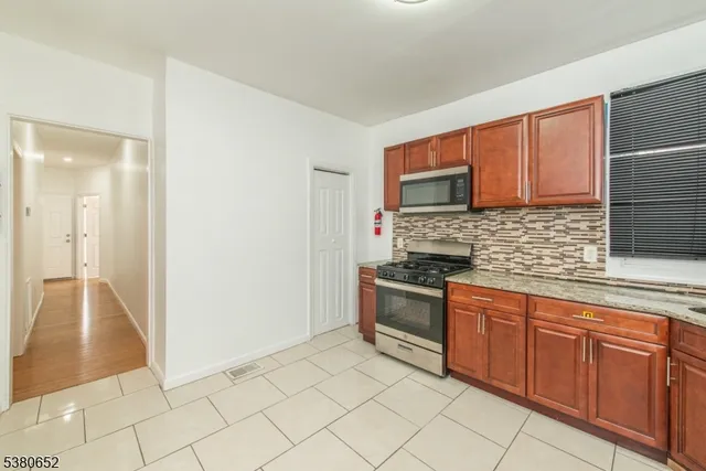 a kitchen with granite countertop a sink stove and cabinets