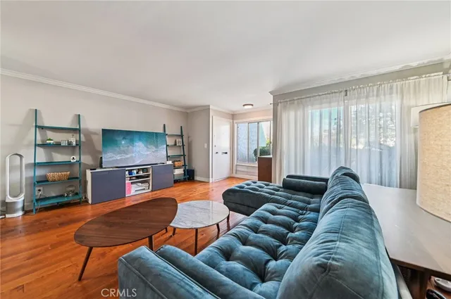 a living room with furniture a flat screen tv and a large window