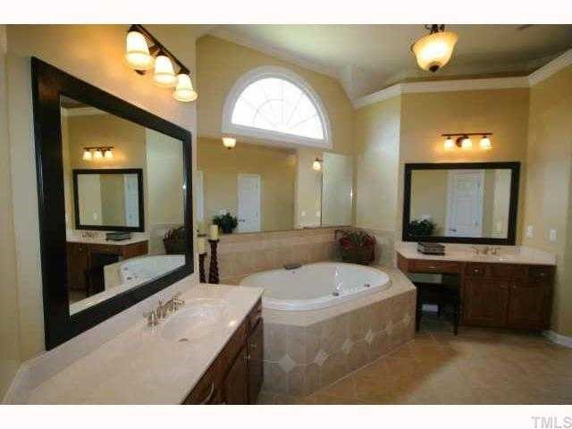 2005 Falls Farm Crossing Raleigh, NC 27614 - Photo 8 of 12 a bathroom with a sink a large mirror and a bathtub
