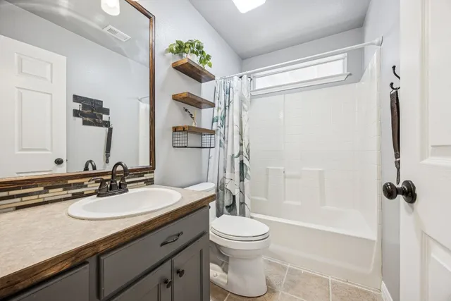 a bathroom with a granite countertop sink toilet mirror and shower