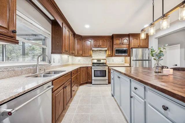 a kitchen with stainless steel appliances granite countertop counter space a sink and cabinets