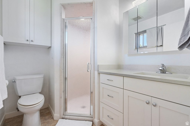 865 South 325 West Orem, UT 84058 - Photo 23 of 38 Bathroom featuring a glass-enclosed shower, white vanity with integrated sink, chrome faucet, white cabinetry, and a wall-mounted medicine cabinet