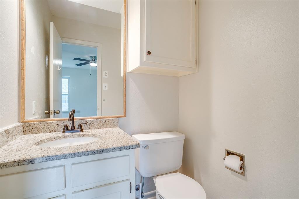 709 North Ave B Springtown, TX 76082 - Photo 20 of 32 a bathroom with a granite countertop toilet sink and mirror