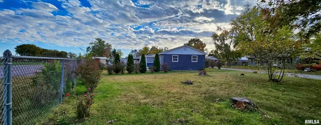 a view of a big house with a big yard and large tree