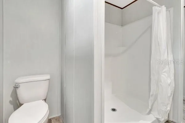 a white toilet sitting next to a shower