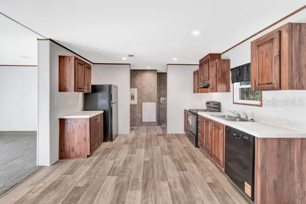 a kitchen with a refrigerator a sink and dishwasher with wooden floor