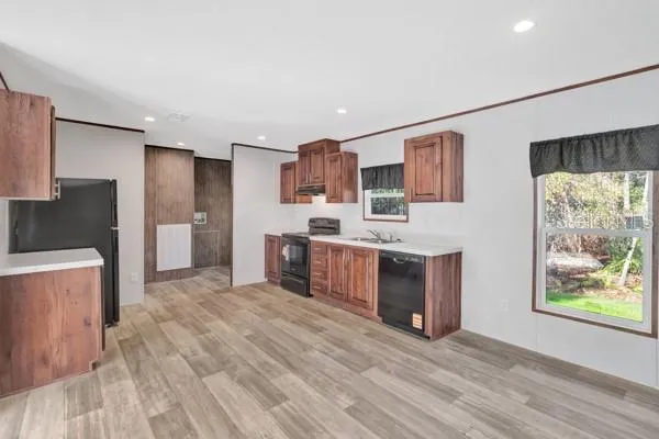 a large kitchen with stainless steel appliances granite countertop a stove a sink and a refrigerator