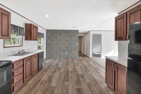 a large kitchen with a sink and wooden floor