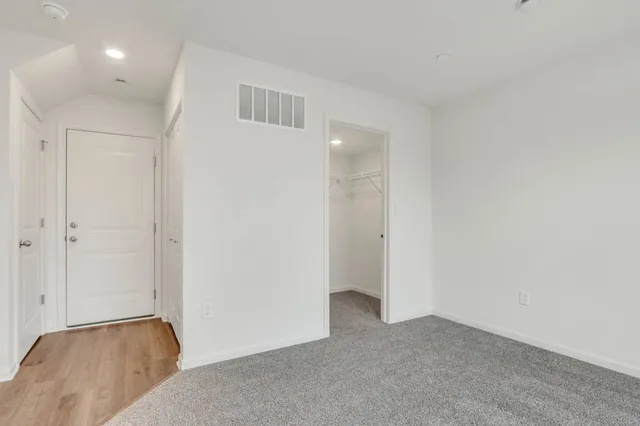 an empty room with windows and closet