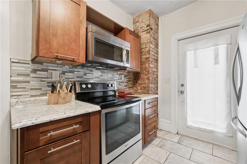 1523 Evergreen Road Pittsburgh, PA 15209 - Photo 19 of 35 a kitchen with stainless steel appliances granite countertop a stove and a microwave