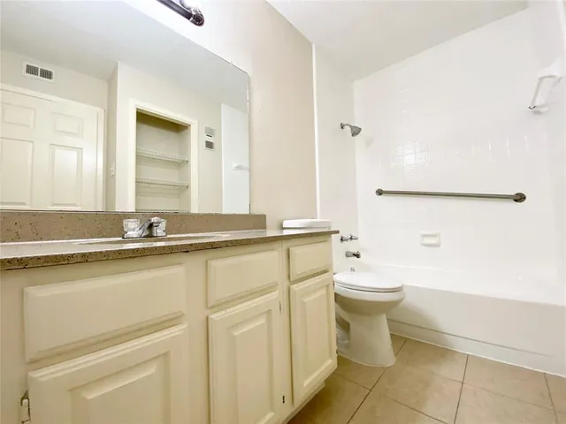 a bathroom with a granite countertop sink toilet and mirror