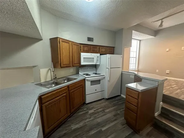 a kitchen with a sink a stove a refrigerator and a microwave