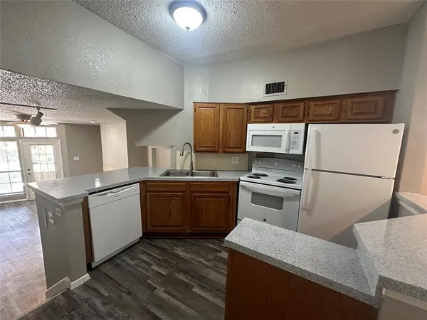 a kitchen with granite countertop a sink a stove and cabinets