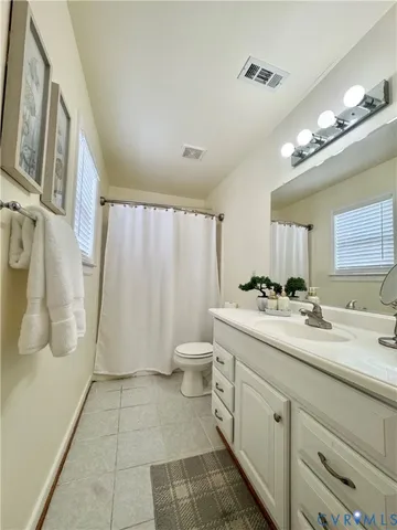 a bathroom with a double vanity sink toilet and a mirror
