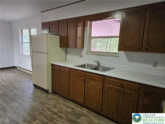 a kitchen with a sink a refrigerator and window
