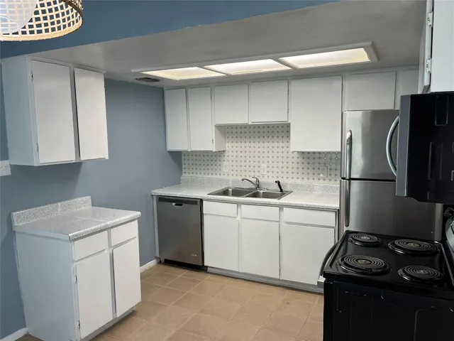 a kitchen with a sink appliances and cabinets