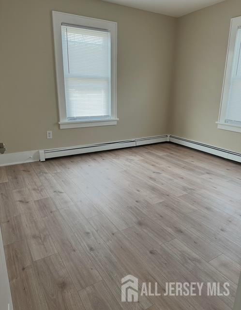 165 Emerson Street, Unit 2 Carteret, NJ 07008 - Photo 2 of 10 an empty room with wooden floor and windows