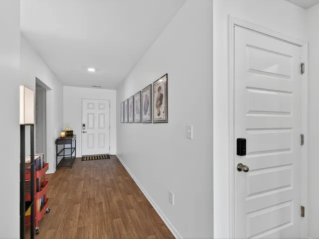 a view of a hallway with wooden floor and closet