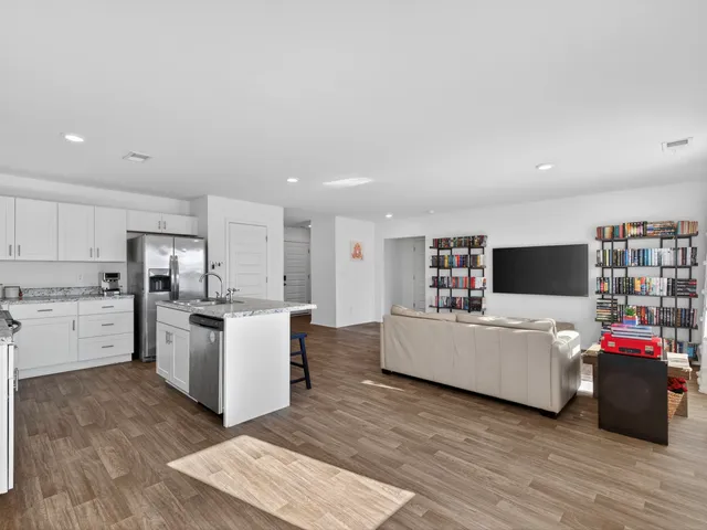 a living room with furniture and kitchen view