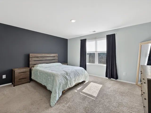 a bedroom with a large bed and a window